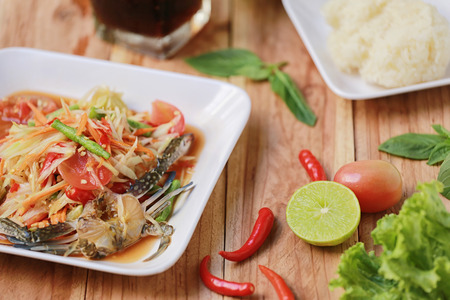 SOM TUM,Thai foods or papaya salad in spicy taste and is popular in thailand on wooden table background.の写真素材