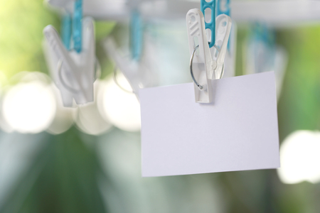 white paper notes hanging in a clothesline on green bokeh background.の写真素材