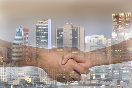 double exposure handshake and city Skyscraper background in concept of start business and initial investment.の写真素材