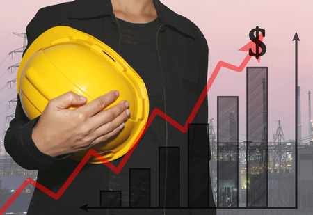 business woman hug a yellow helmet on power plant background and bar graph in concept of profit and...