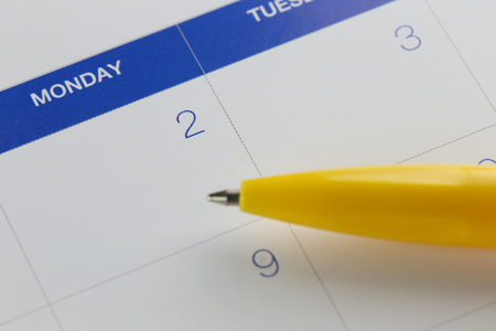 yellow pen points to the number 2 on calendar background in concept of appointment schedules and important dates.の写真素材