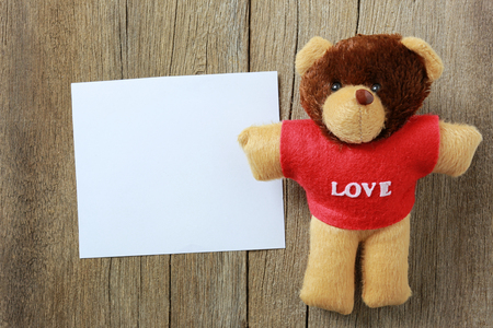 Teddy Bear is placed on old brown wood floor and have copy space to your input idea in work.の写真素材