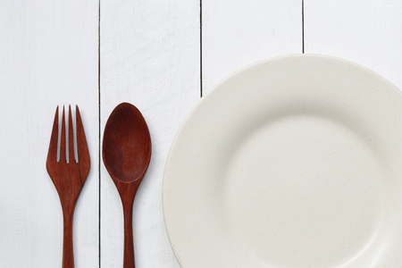 Plate and spoon on white wood floor,concept of food kitchen accessories.の写真素材