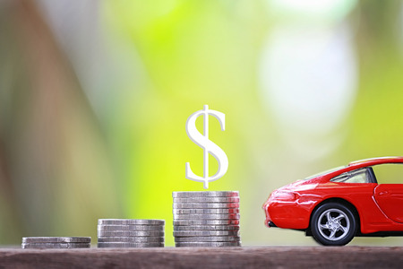 Concept of investing in automotive business,Coin pile graph and red toy car.の写真素材