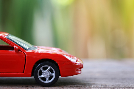 Red toy car on wooden floor in concept of automotive business.の写真素材