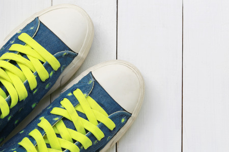 Old sneakers on white wooden floor background and have copy space for design in your work.の写真素材