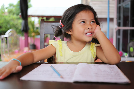Asian child girl use Pencil write letters on the book in concept of education and learning.の写真素材