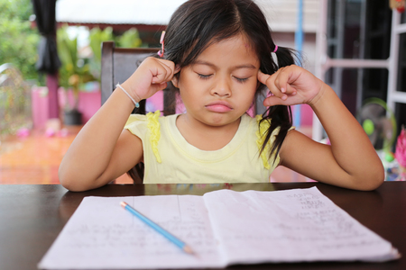 Asian child girl use Pencil write letters on the book in concept of education and learning.の写真素材