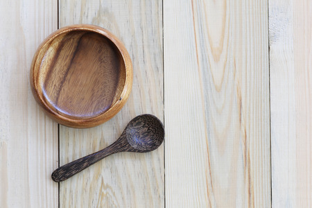 Wooden bowl and wooden spoon on wood background and have copy space to design in your work.の写真素材