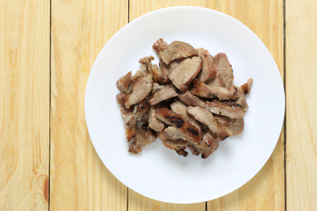 roasted pork of local thai foods style in white dish on wooden floor.の写真素材