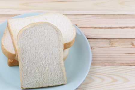 Sliced bread Stacked in green dish on wooden floor and have copy space to design in your work.