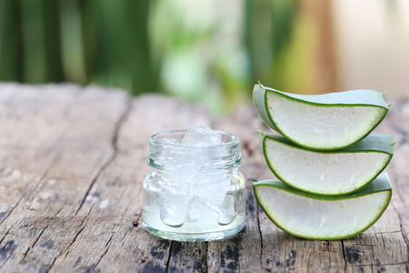 Fresh aloe vera and jelly in Glass bottle placed on a wooden floor and have copy space to input for design in your work.の写真素材