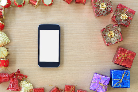 Empty Screen of Smart Phone and equipment decorations are placed on a brown wooden floor and have copy space to input ideas of your work.の写真素材