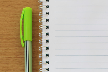Notebooks and pens are placed on a brown wooden floor and have copy space for design in your work.の写真素材