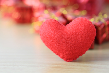 red heart placed on a wooden floor on red gift box of blur background for design in your Concept in Valentine's Day or special day.の写真素材