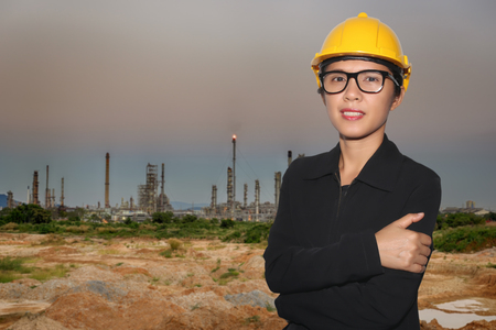 Engineer of women in smiling on oil refinery twilight background for design concept of energy building in your work.の写真素材