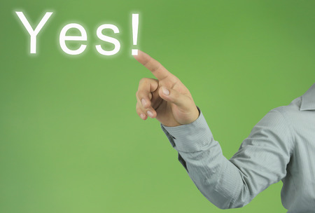 hand of the businessman pointing to the Yes! text on green background and have copy space for design in your work concept.の写真素材