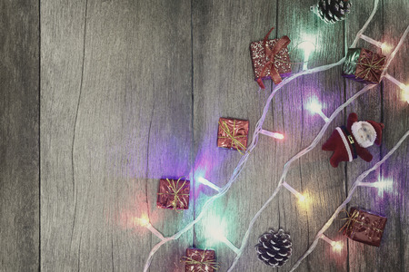 Colorful of Christmas lights on brown wooden floor and have copy space for your design.