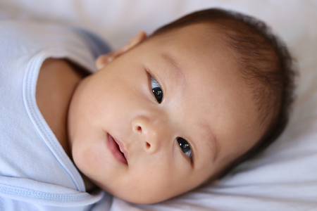 Asian Infant on a bed in face focus,concept of healthy growth.の写真素材