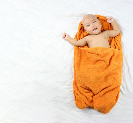 Asian Infant sleep on the bed and laughing of happy in concept of health and growth.の写真素材