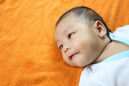 Asian Infant on a bed in face focus,concept of healthy growth.の写真素材