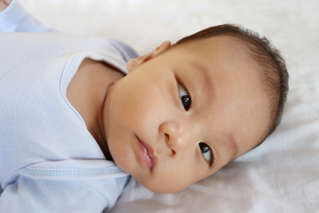 Asian Infant on a bed in face focus,concept of healthy growth.の写真素材