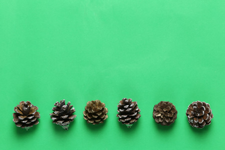 Pine cones on green paper art background and have copy space for design in Christmas concept.の写真素材