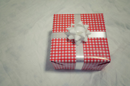 Red Gift box on the gray cloth for Christmas, new year, valentine day or anniversary day and have copy space for design in your work concept.の写真素材