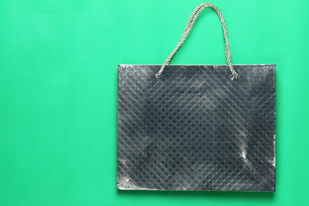 Silver shopping paper bag on green background and have copy space for design in your concept.の写真素材