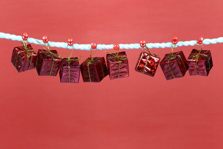 Red gift box hang on the clothesline and have copy space with red background for design in your work concept.の写真素材