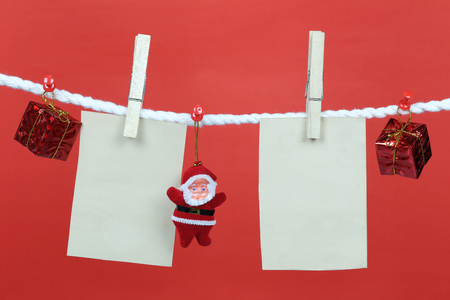 Empty note paper hang on the clothesline and have copy space with red background for design in your work concept.の写真素材