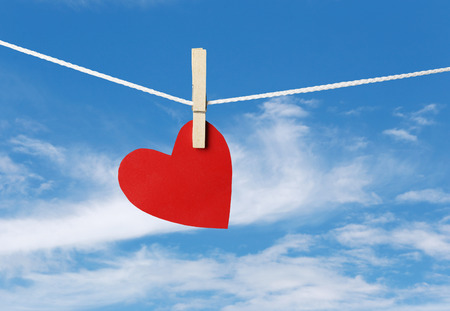 Red paper hearts hanging on the rope in valentine day concept and sky background.の写真素材