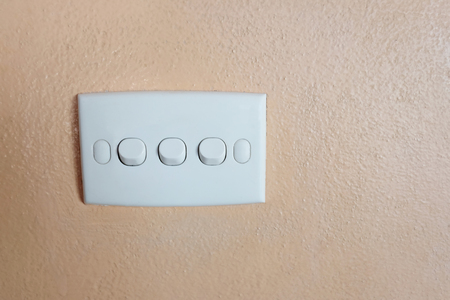 Push button of white switch on orange wall and have copy space for design in your work concept.の写真素材