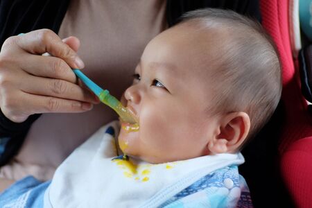 Asian boy with strabismus and eating food,Portrait of infant in concept of health and medical.の写真素材
