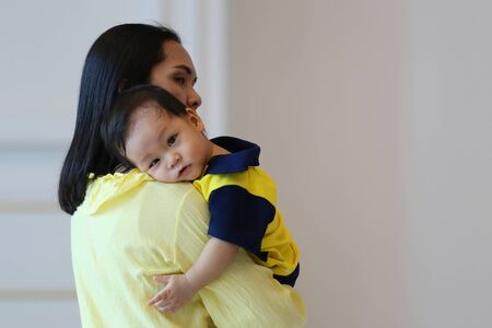 Asian mother carrying a baby,concept for mother's love for the baby in happiness.の写真素材