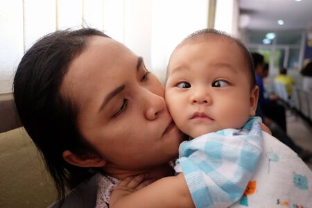 Asian boy with strabismus and mom,Portrait of infant in concept of health and medical.の写真素材
