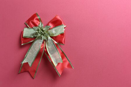 Red ribbon bow on art paper background and have copy space for your design.の写真素材
