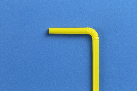 Yellow drinking straw in a blue paper background and have copy space for your design.