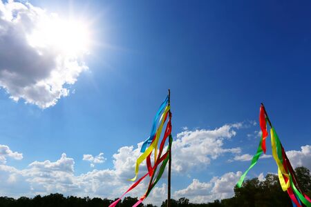 Colorful cloth tied wooden pole showing religious symbols in a daytime.の写真素材