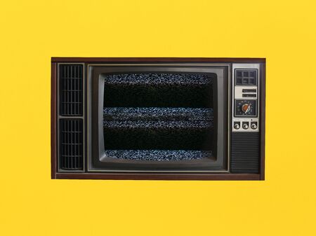 Old vintage televisions that can't receive signals on yellow background.の写真素材
