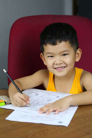 Asian boy is doing his homework,concept of studying on-live at home,Thailand boy in learning by...