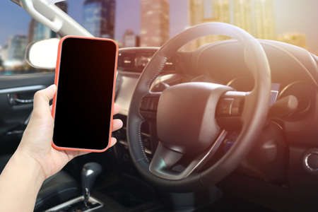 Blank smartphone screen on hand of man in the front of the car and have copy space.