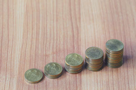 Coin stack of bar graph on the wooden floor in business idea and profit concept.の写真素材