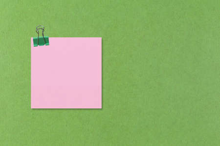 Colorful square note paper on green paper background and have copy space for you design.