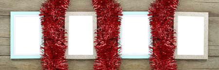 Empty vintage photo frame on wooden floor and red tassels for Christmas and New Year decorations.の写真素材