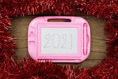 Red Christmas decorations and 2021 text frame on the old wooden floor for design in your work.