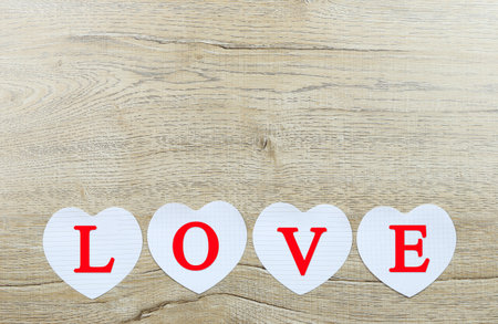Letter word of love on white paper heart shape on wooden floor and have copy space.の写真素材