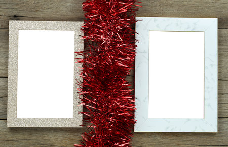 Empty vintage photo frame on wooden floor and red tassels for Christmas and New Year decorations.の写真素材