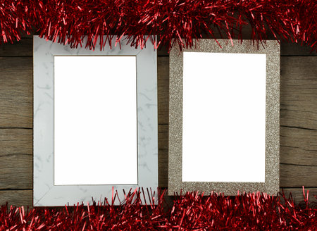 Empty vintage photo frame on wooden floor and red tassels for Christmas and New Year decorations.の写真素材