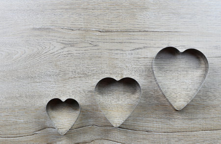 Heart-shaped mold rests on a wooden table and has a copy space for design in love and valentine day.の写真素材